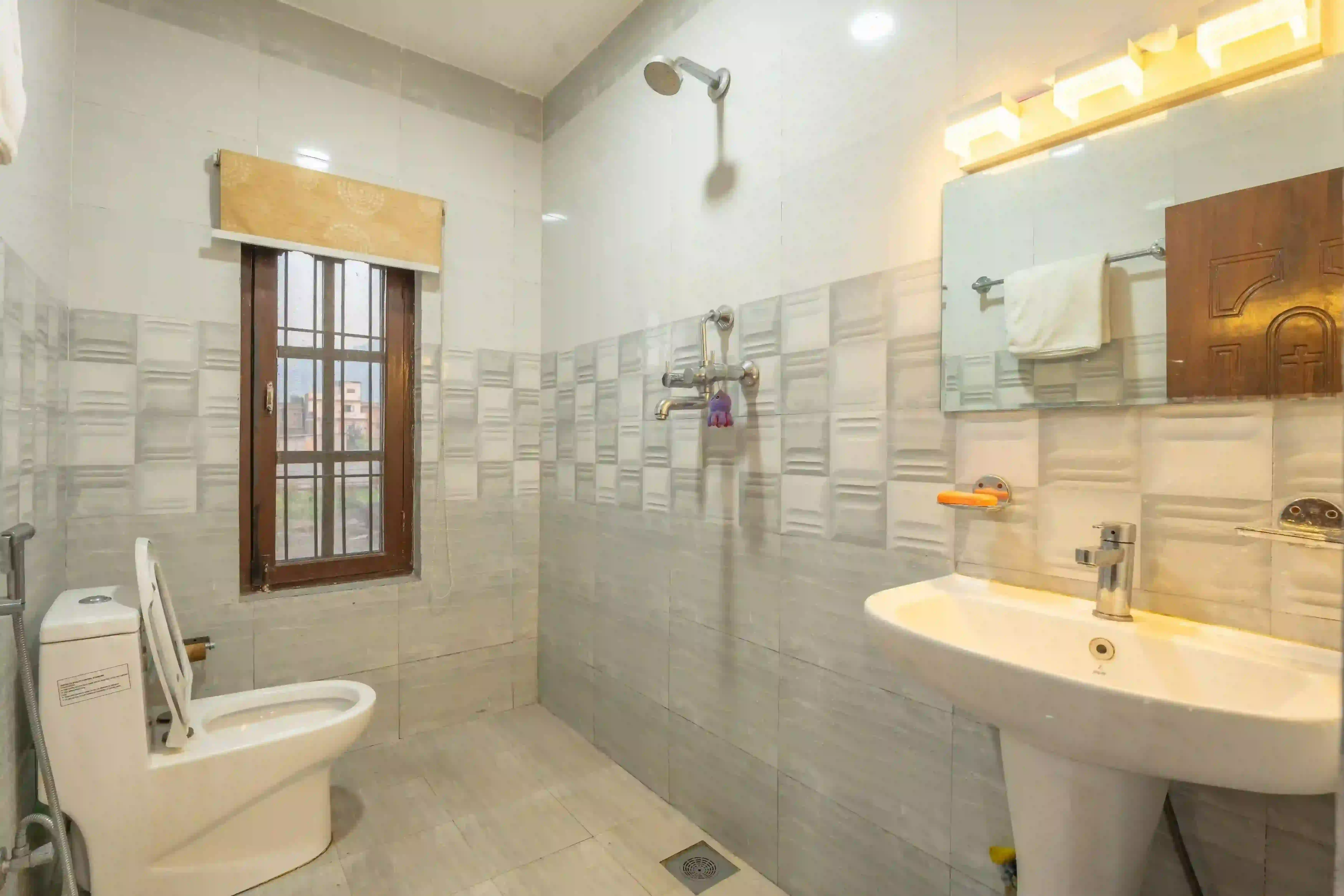 Clean shared bathroom for deluxe rooms at Aananda Homestay